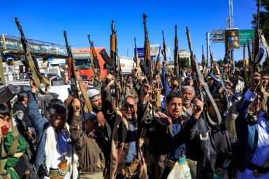 Armed Yemeni supporters of the Iran-backed Huthi movement, brandish their weapons as they rally in the capital Sanaa on January 27, 2022 to protest against the Saudi-led coalition's intervention in their country