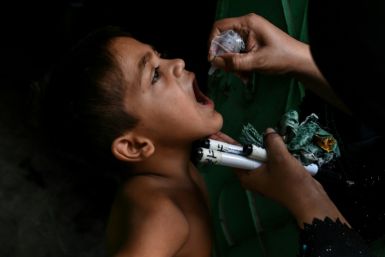 A child receives a dose of polio vaccine during a door-to-door vaccination campaign in Karachi on September 9