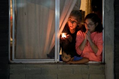 A family look from their window in the city of Bogota on August 6, 2020