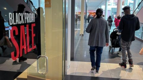 A family walks past a store advertising a Black Friday sale near Pentagon City Mall in Arlington, Virginia