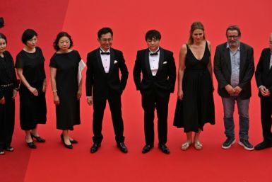 Goro Miyazaki (centre-left) arrives to receive the honorary Palme