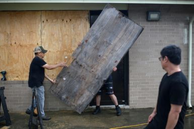 A group of men board up a restaurant in Port Lavaca, Texas, on July 7, 2024, as they prepare for the arrival of tropical storm Beryl
