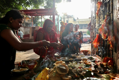 Hindu women offer prayers to thank deities for the birth of a child