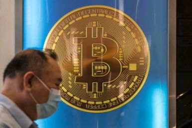 A man walks past a bitcoin poster in Hong Kong on April 15, 2024