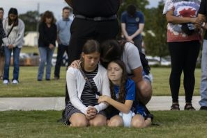 A mother and her children bow their heads in prayer at a vigil for the victims of the Apalachee High School shooting in Winder, Georgia