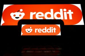The Reddit logo displayed on a cell phone and computer monitor