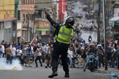 A riot police officer uses tear gas against demonstrators during a protest by opponents of Venezuelan President Nicolas Maduro's government in the Catia neighborhood of Caracas on July 29, 2024