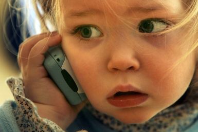 A toddler plays with a phone
