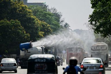 A vehicle of the Dhaka North City Corporation sprays water along a busy road to lower the temperature amidst a heatwave
