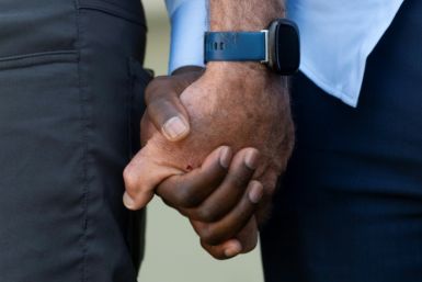Viles Dorsainvil (R), the Executive Director of the Haitian Community Help and Support Center, holds hands with a US pastor after religious leaders called for calm among growing tensions about the Haitian population in Springfield