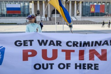A woman holding a Ukranian national flags and a banner takes part in a protest ahead of a visit by Russian President Vladimir Putin in Ulaanbaatar, Mongolia's capital city on September 2, 2024.